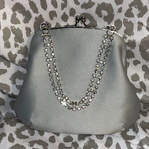 Small silver party clutch with rhinestone handle and clasp closure